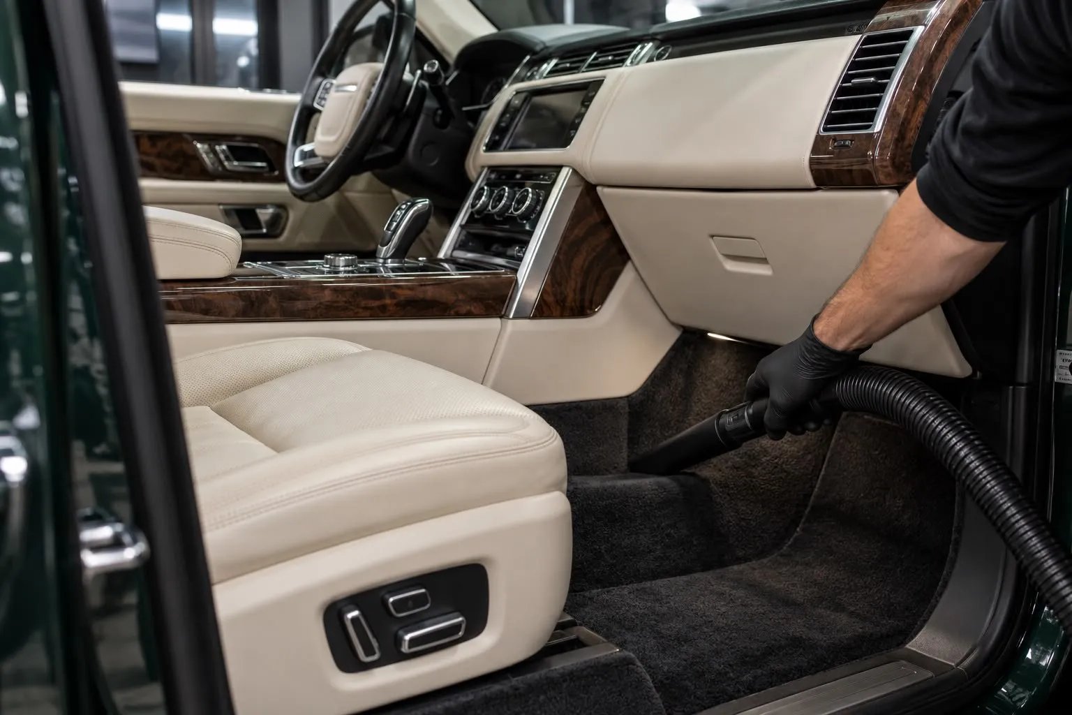 Stofzuigen van de vloer van een luxe interieur met crèmekleurig leder